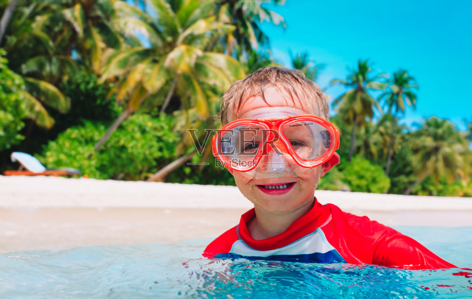 快乐可爱的男孩戴着面具在海里游泳照片摄影图片