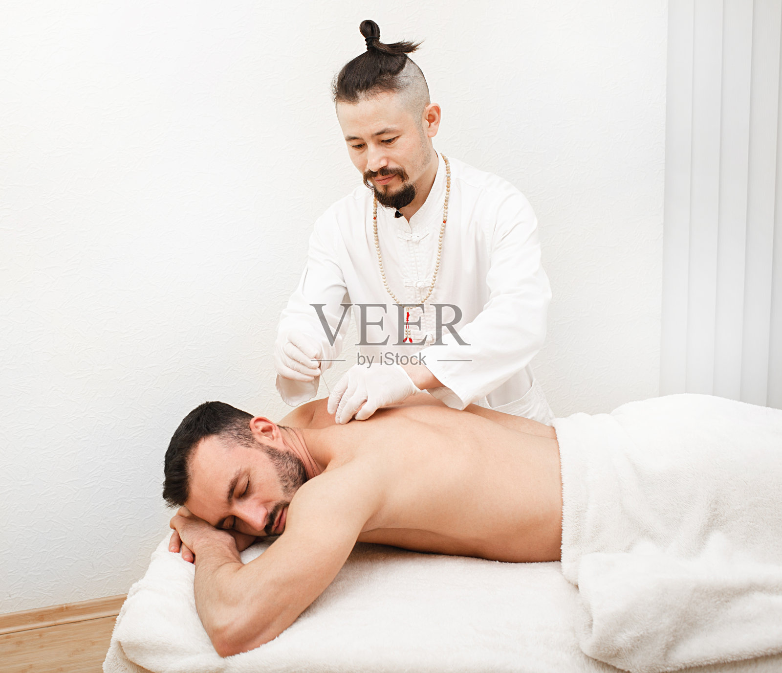 男子对针灸治疗背部的程序。中国传统医学照片摄影图片