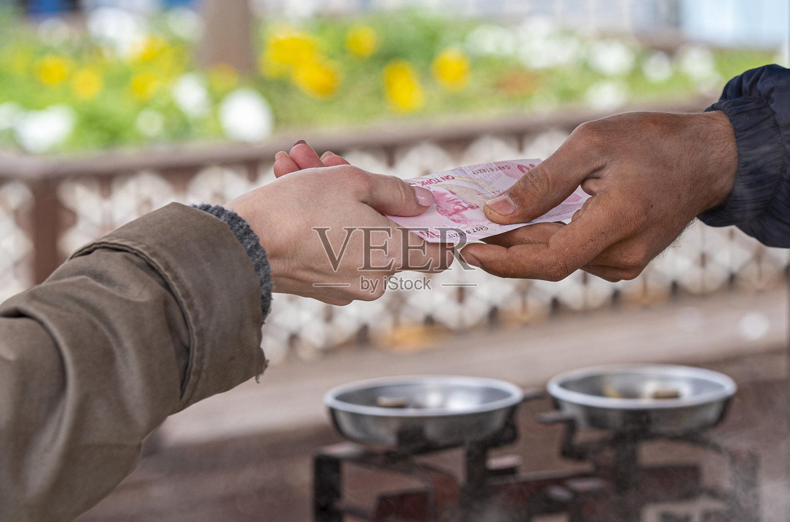 伊斯坦布尔，一名妇女手持10里拉纸币购买街头小吃照片摄影图片