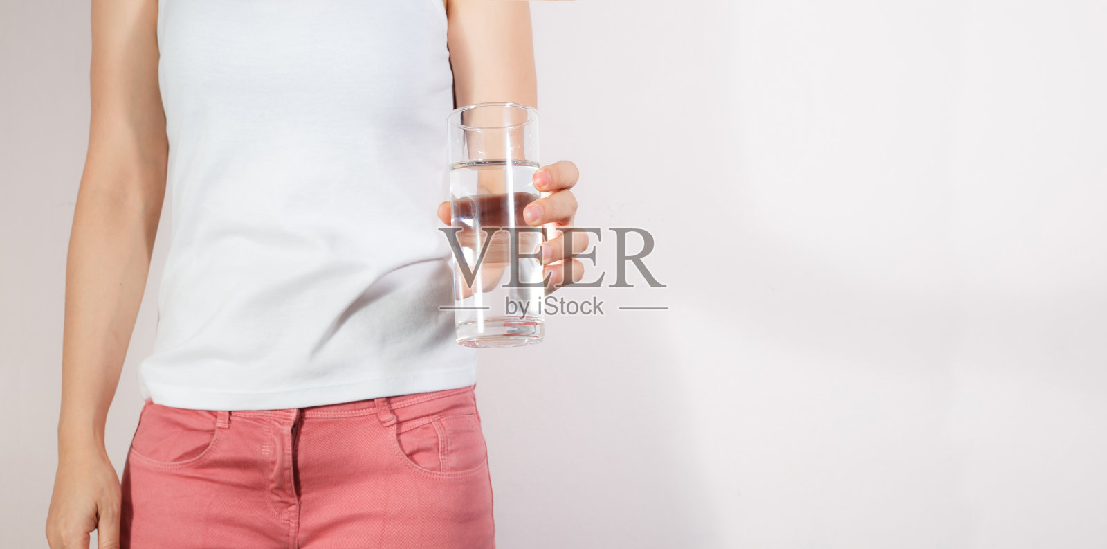 特写胖女人拿着水杯在她的手。卫生保健的概念。照片摄影图片