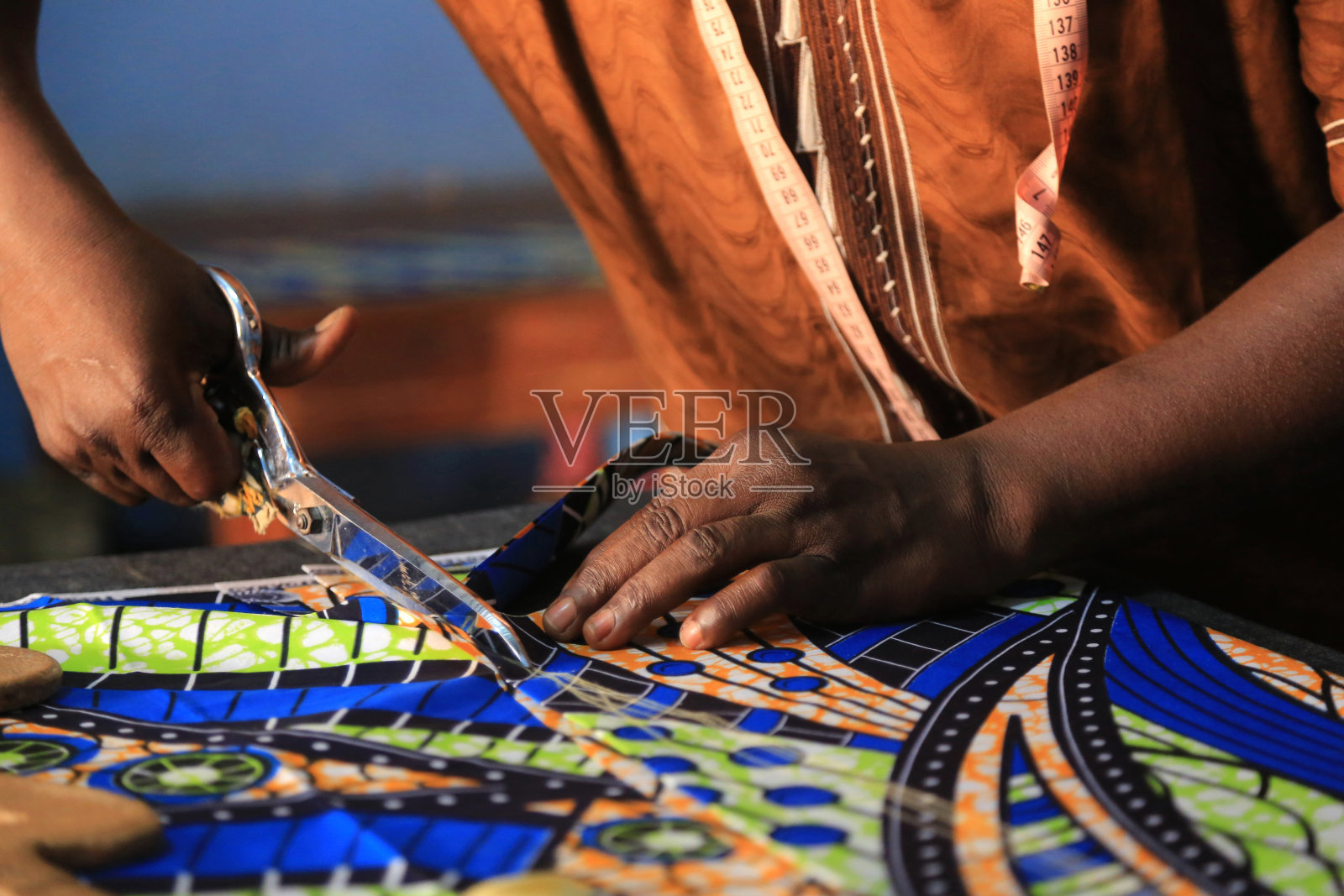 裁缝用一把剪刀裁布。洛美。多哥。西非。照片摄影图片