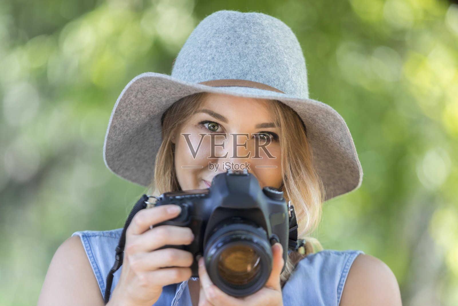 一位年轻的自然摄影师在树林里拍摄了她的肖像照片摄影图片