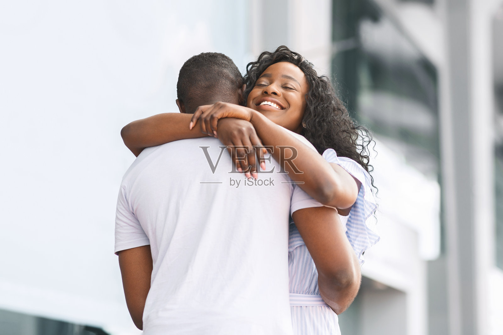 快乐的非洲女人拥抱她可爱的男朋友照片摄影图片