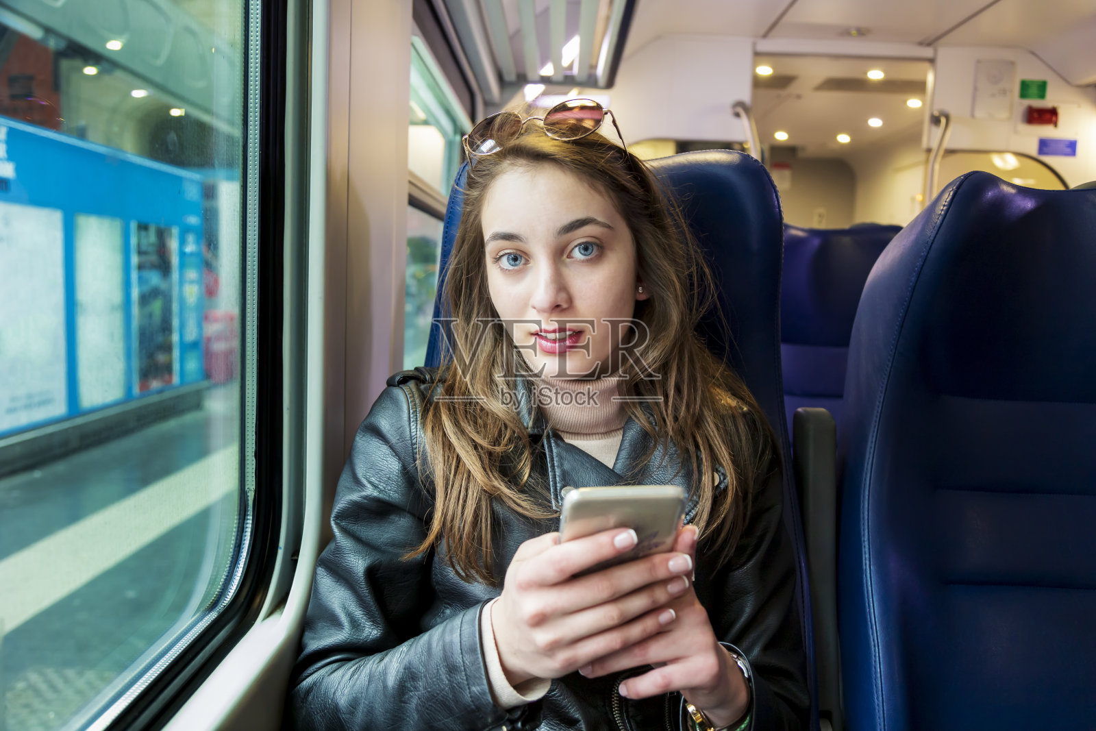 年轻女孩在地铁上使用智能手机照片摄影图片