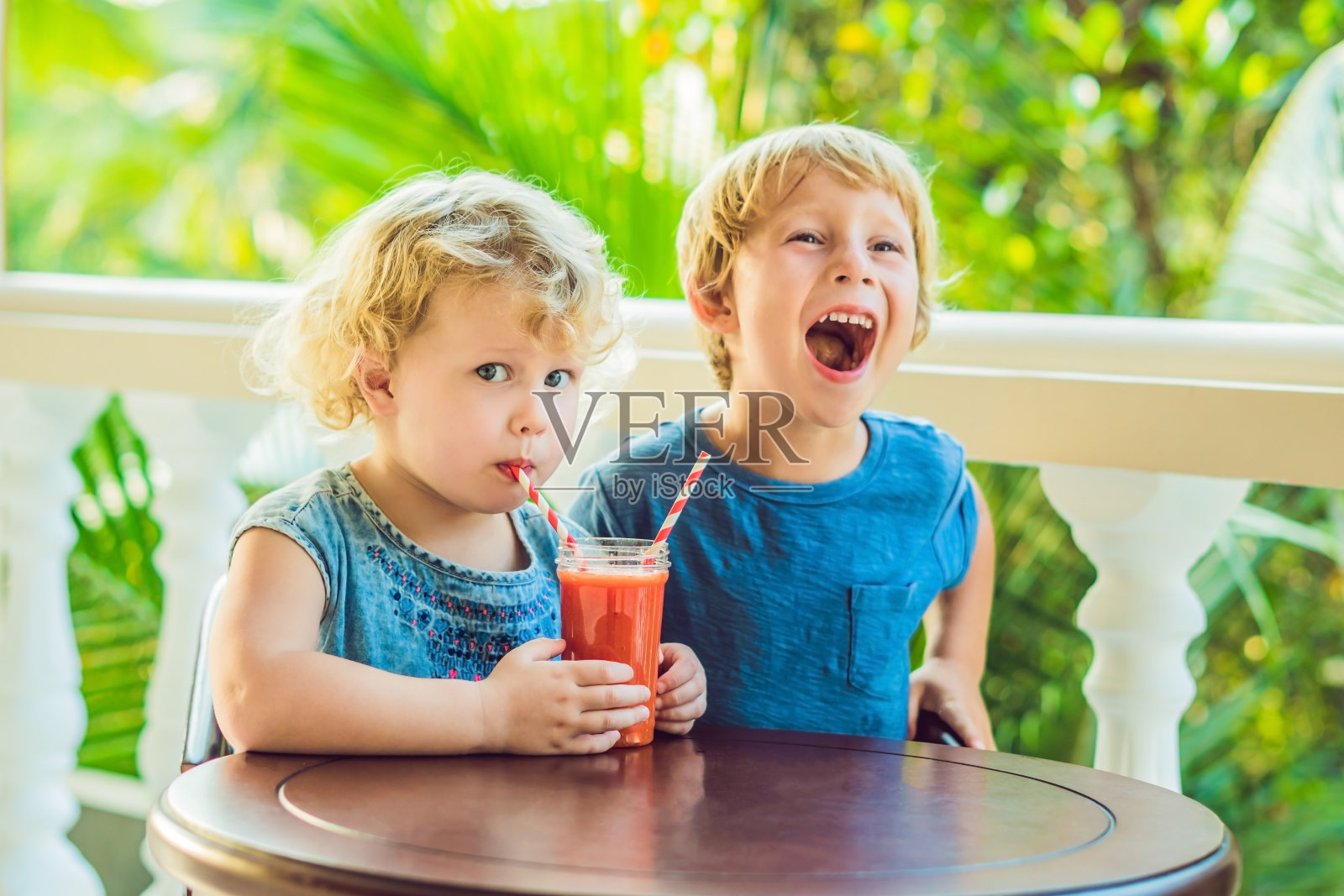 男孩和女孩喝橘子冰沙木瓜照片摄影图片