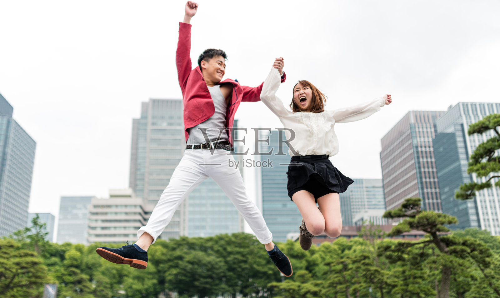 快乐的人们在东京跳跃照片摄影图片