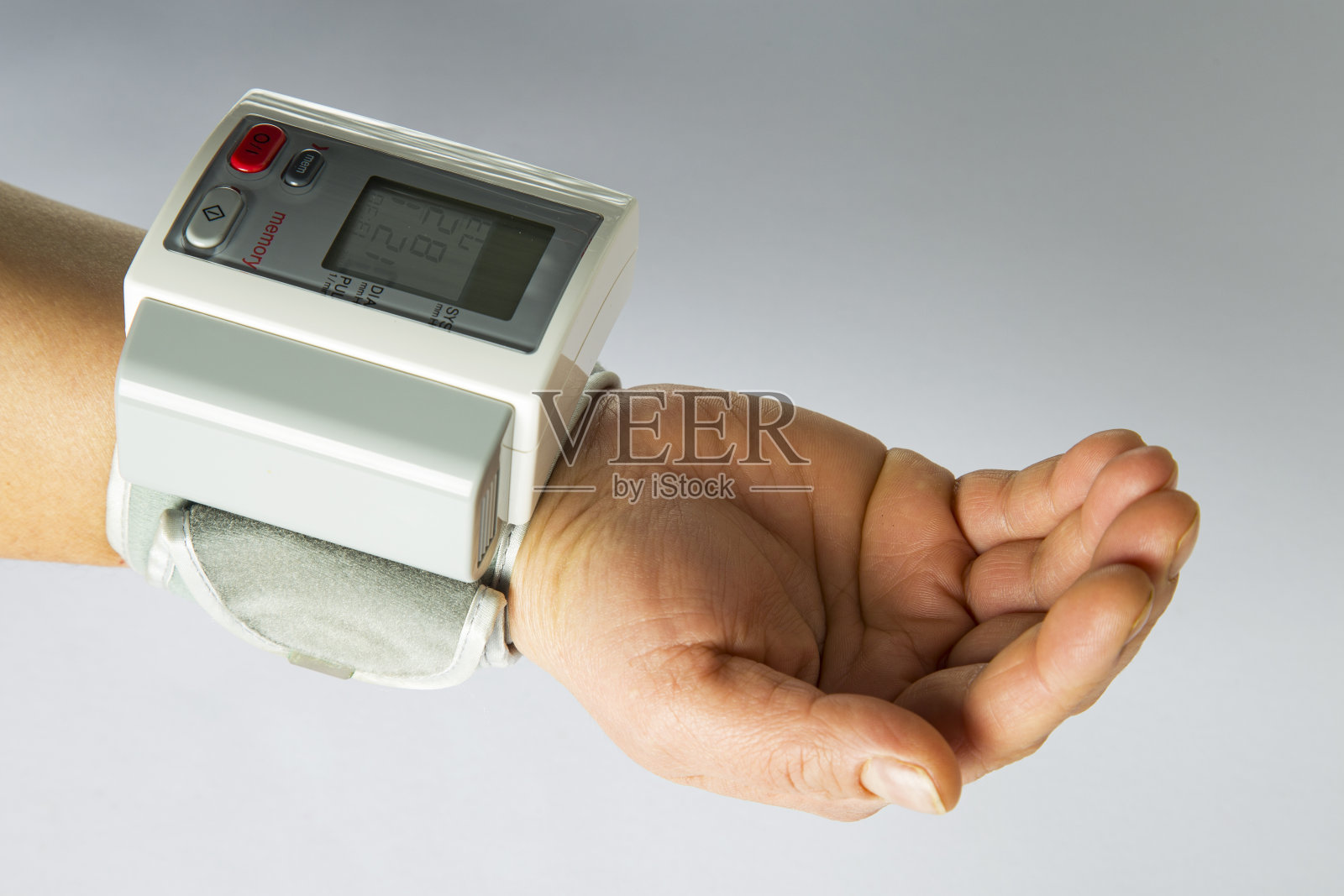 老年人在家在白色背景下测量血压照片摄影图片