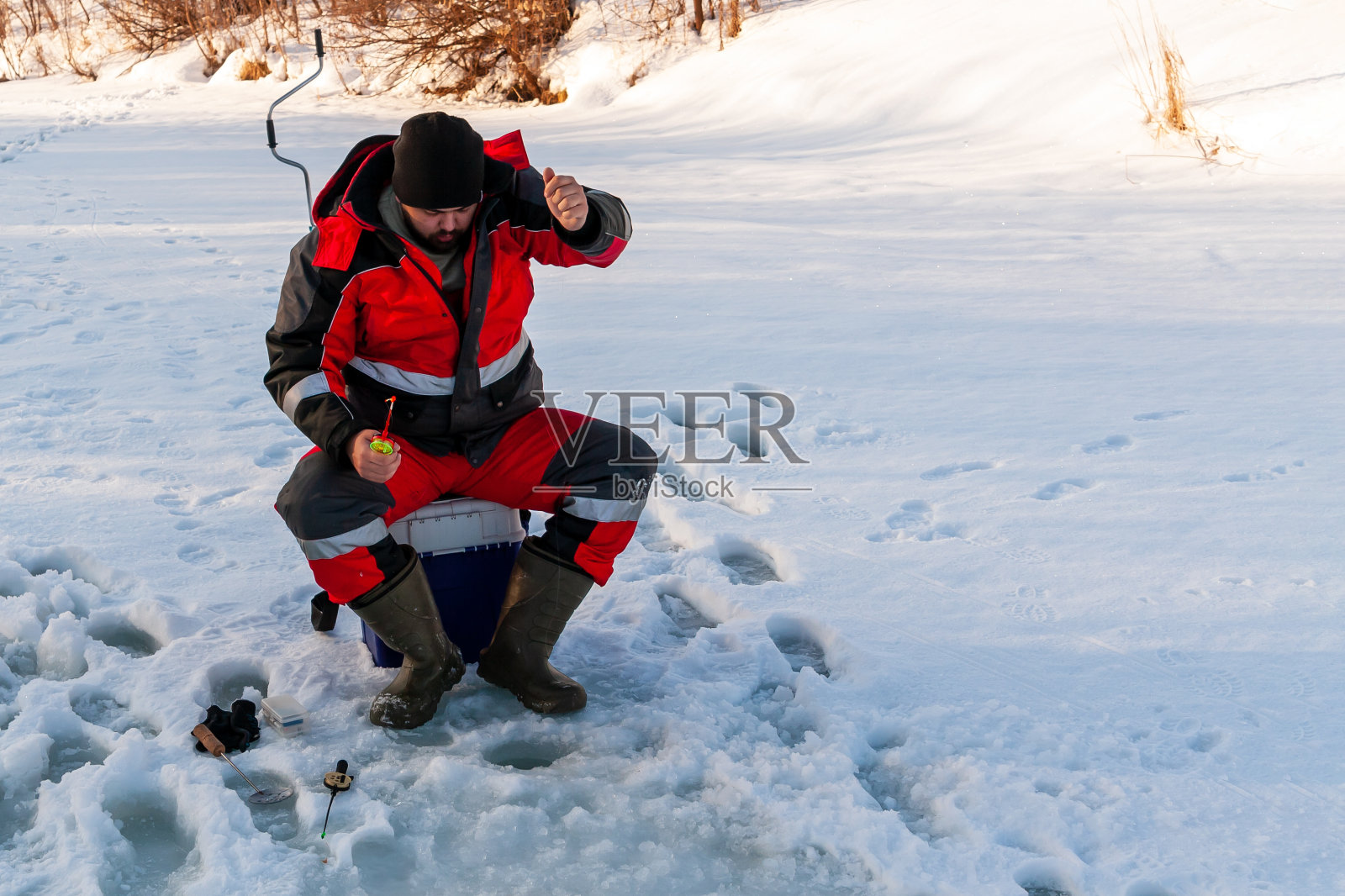 渔夫，特写，在冰上钓鱼。与空间的副本合影。照片摄影图片