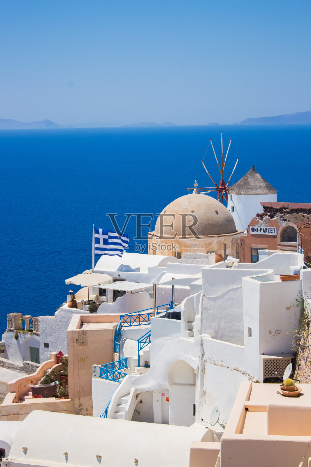在希腊的伊亚-圣托里尼岛，希腊国旗在风中飘扬照片摄影图片