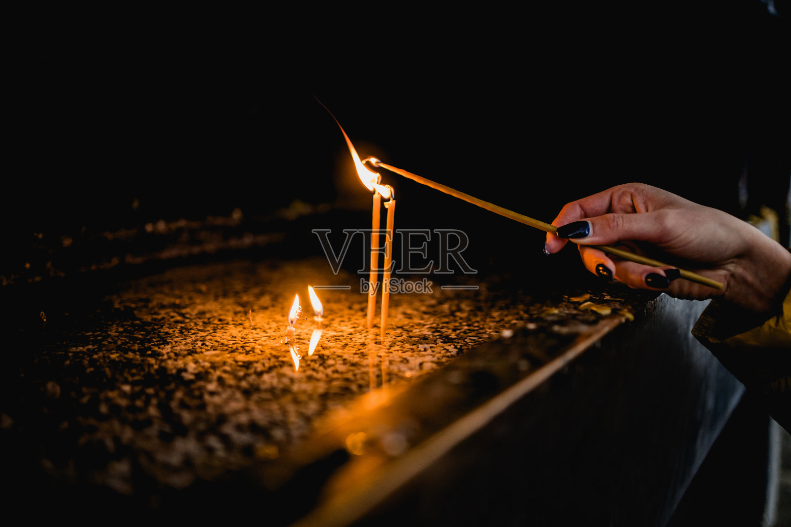 一个女人在教堂里点燃蜡烛照片摄影图片