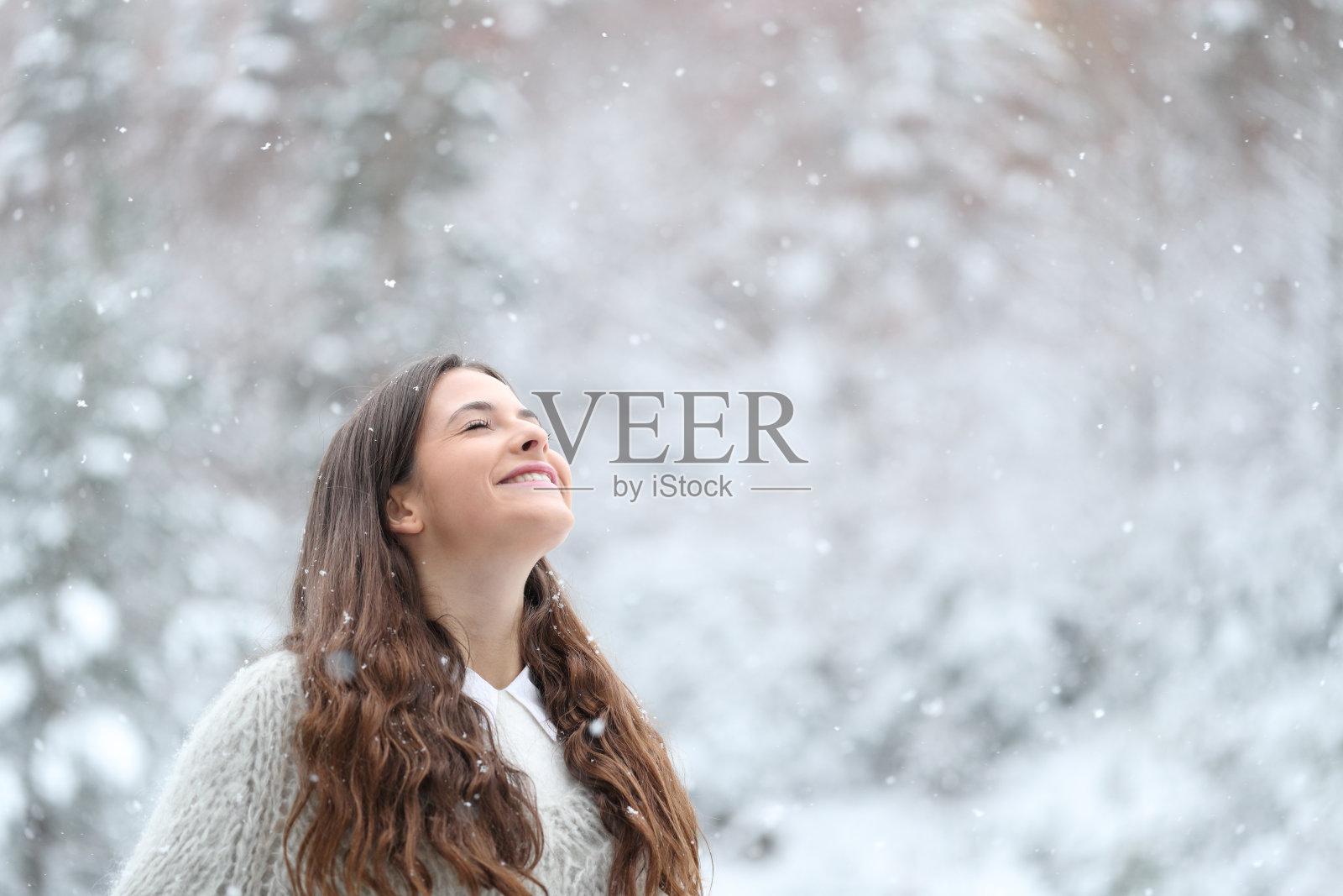 快乐的女孩享受着冬日里的雪天照片摄影图片