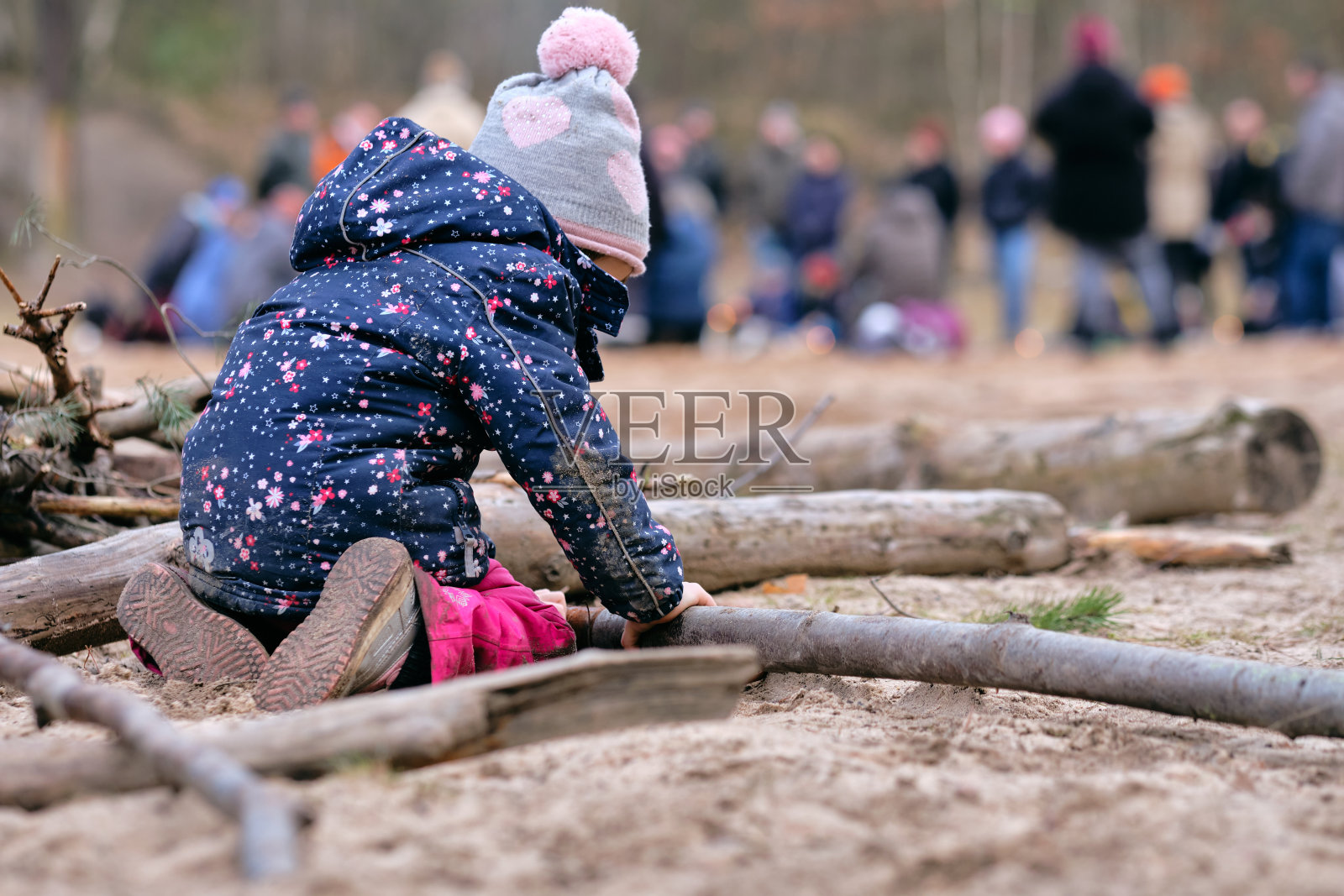 后视图的孩子女孩玩木材在冬天照片摄影图片