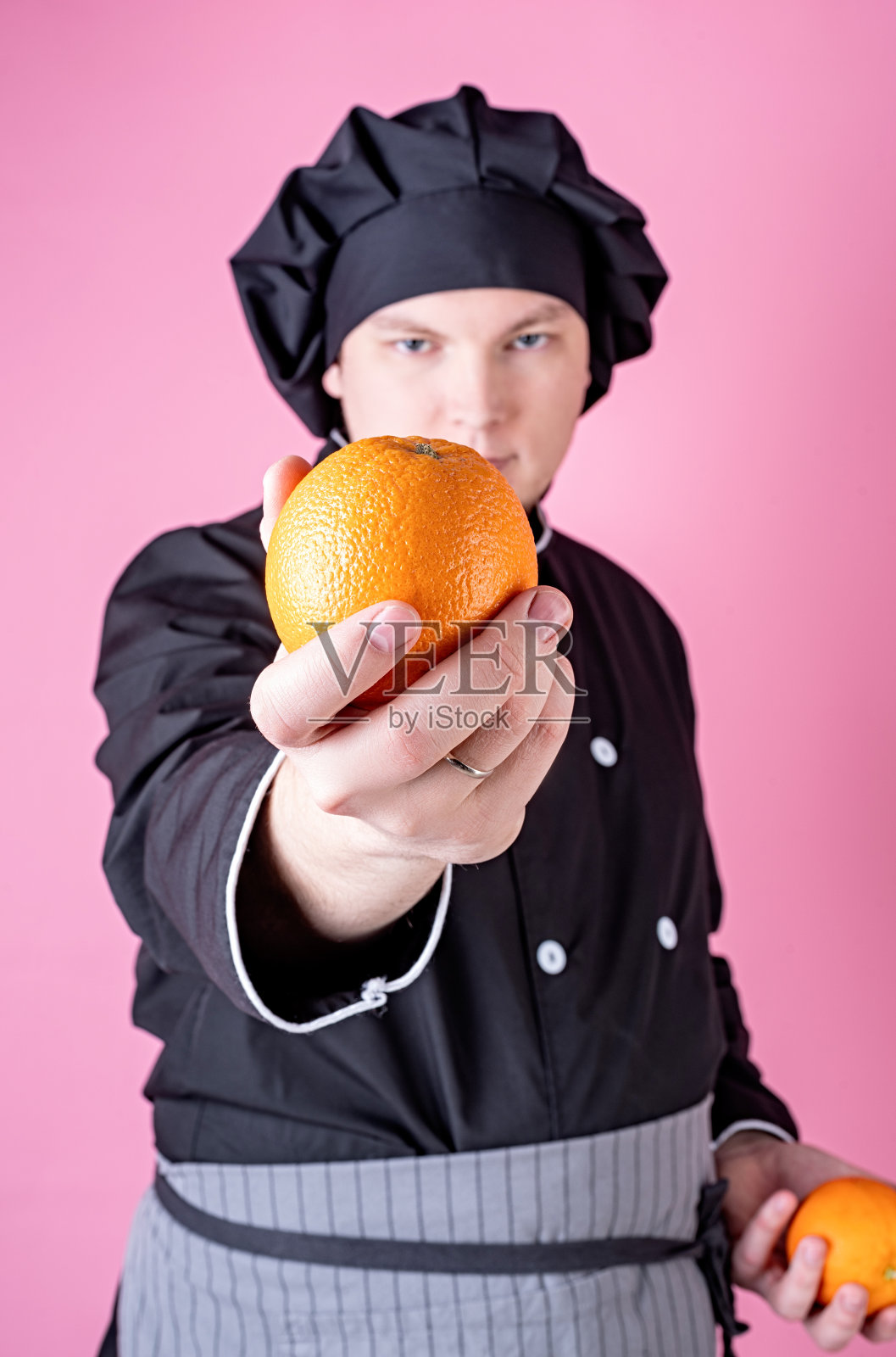男厨师拿着孤立的粉红色橙子拷贝空间照片摄影图片