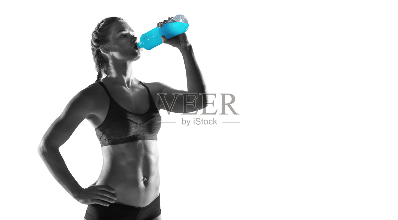 小女孩在训练后喝瓶装水。健身和健康生活理念。黑白图像。照片摄影图片
