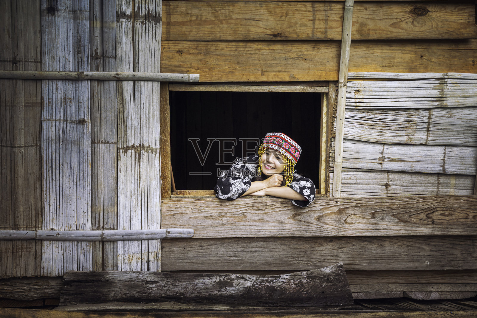 穿着山地部落服装的游客。一个阿卡在窗户上。游客穿着苗族山部落的衣服，坐着移动，靠窗。照片摄影图片
