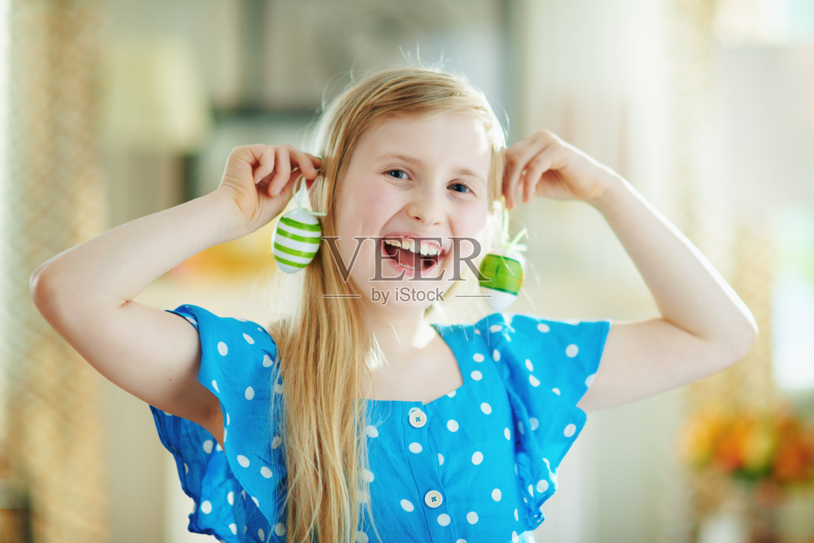 快乐的现代孩子用绿色的装饰蛋做耳环照片摄影图片