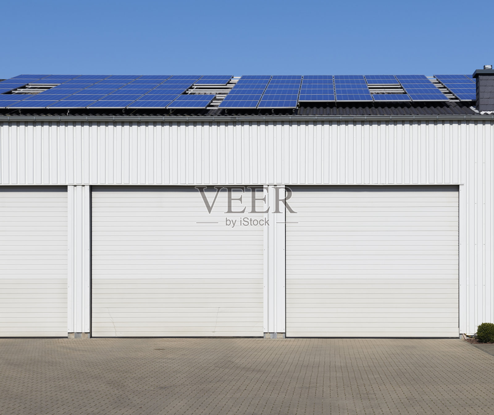仓库的白色卷帘门和太阳能电池板照片摄影图片