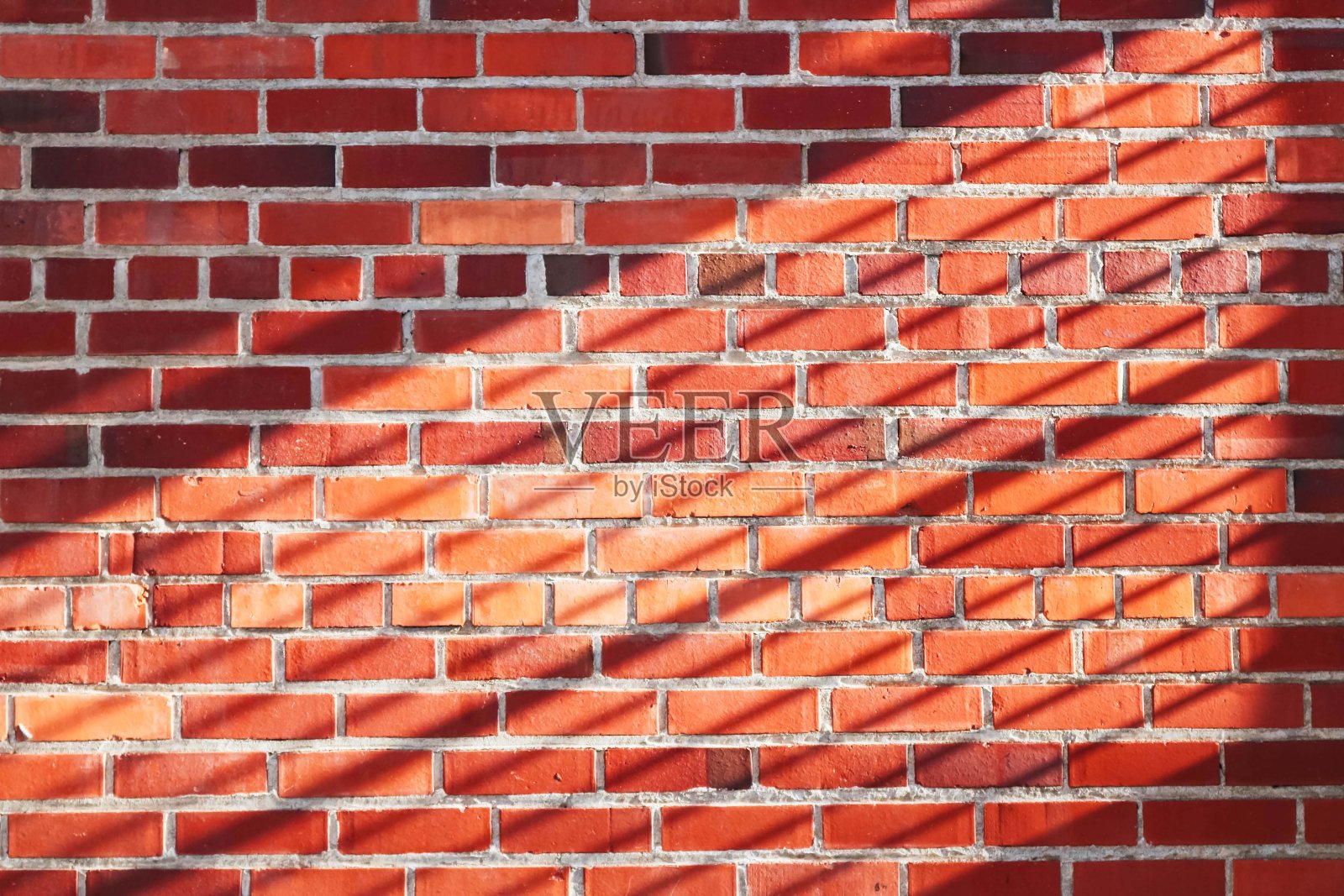 橙色的砖墙背景和阳光的阴影照片摄影图片