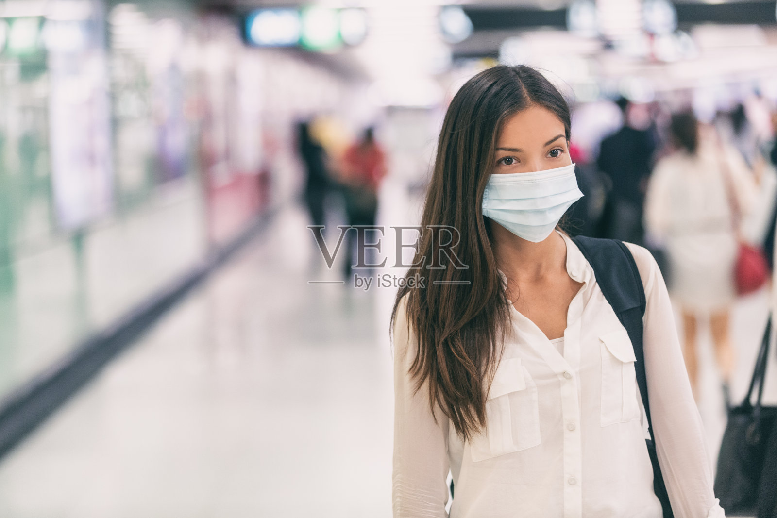 冠状病毒亚洲妇女戴着外科口罩行走在机场火车站的人群中上班通勤到医院照片摄影图片