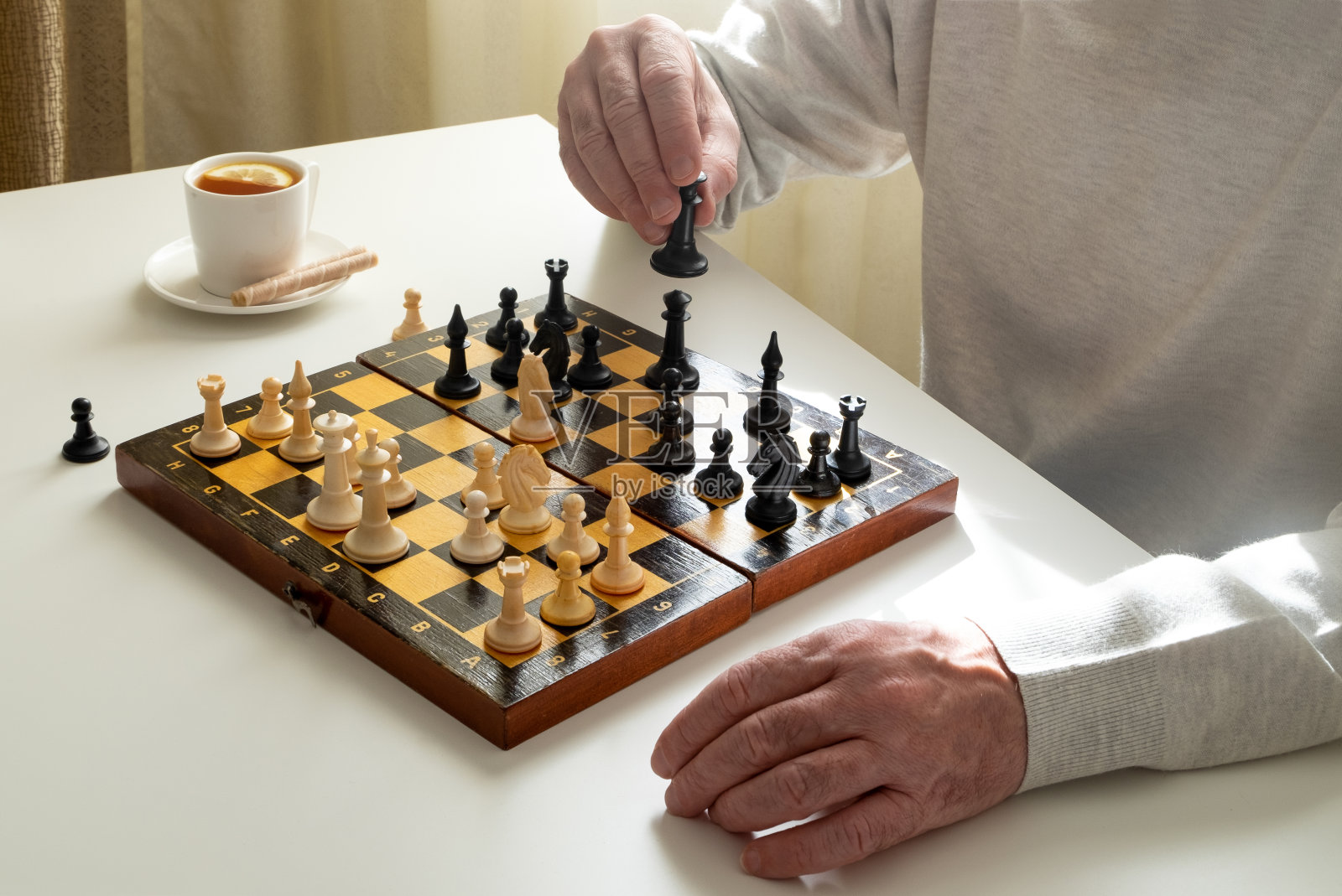 中年男子或退休人员在隔离期间或业余时间下棋。照片摄影图片