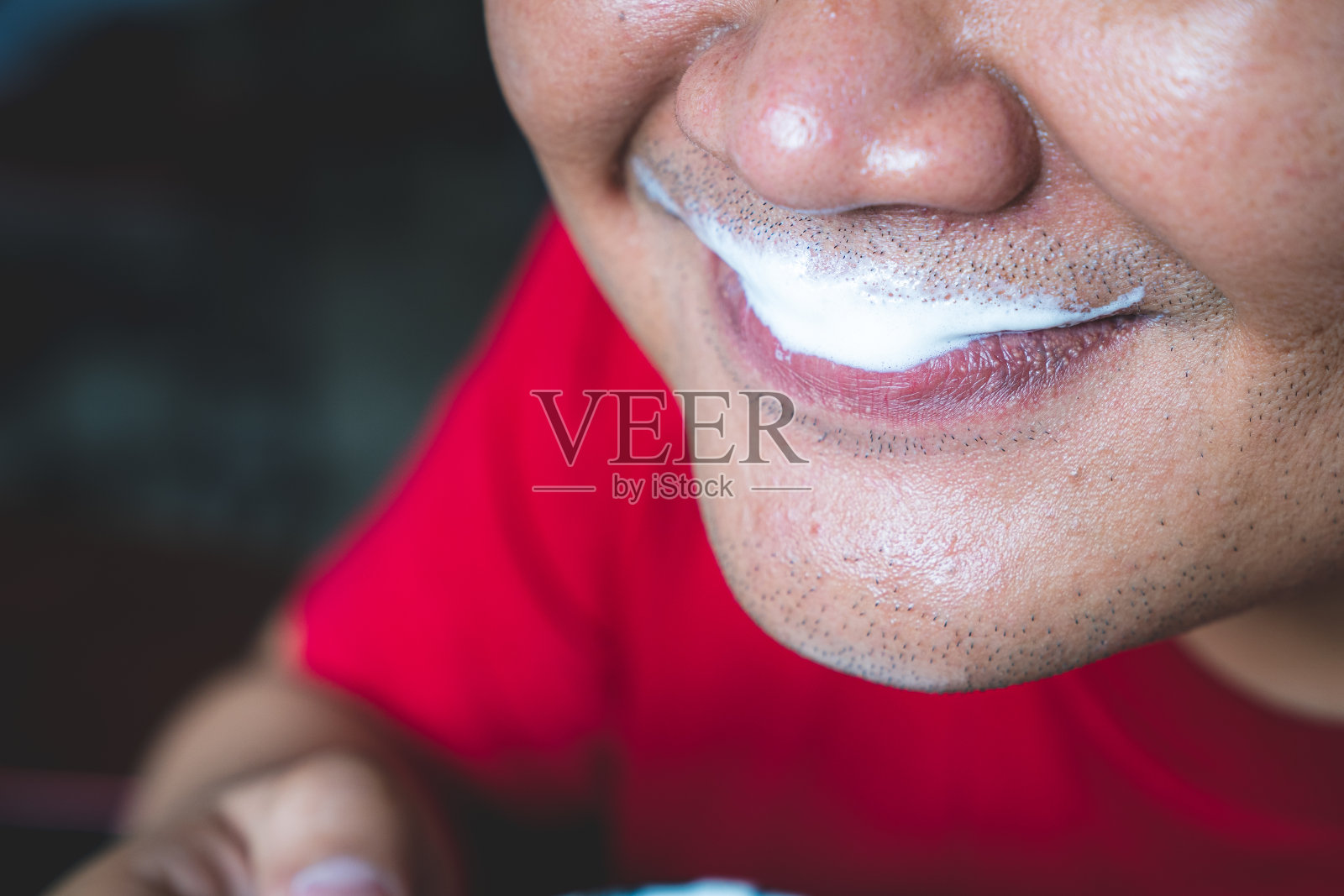 一个男人的嘴唇与牛奶泡沫附着的特写照片摄影图片