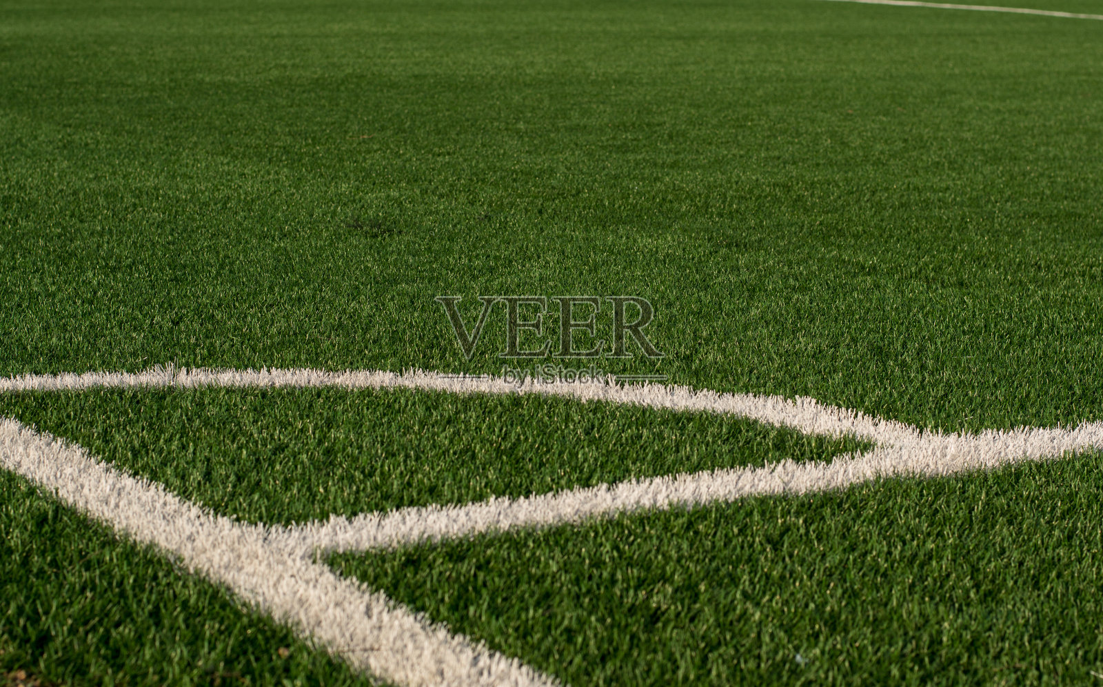 人工绿草，白色边框。足球场用人造草皮。露天体育场的足球场。有选择性的重点照片摄影图片