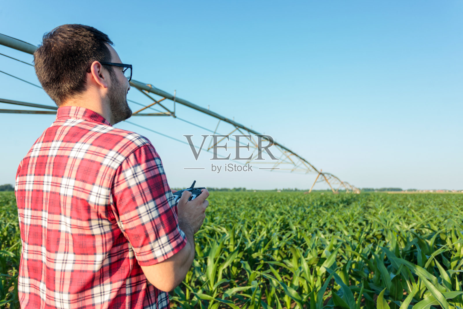 使用无人机检查玉米地的年轻农民或农学家照片摄影图片