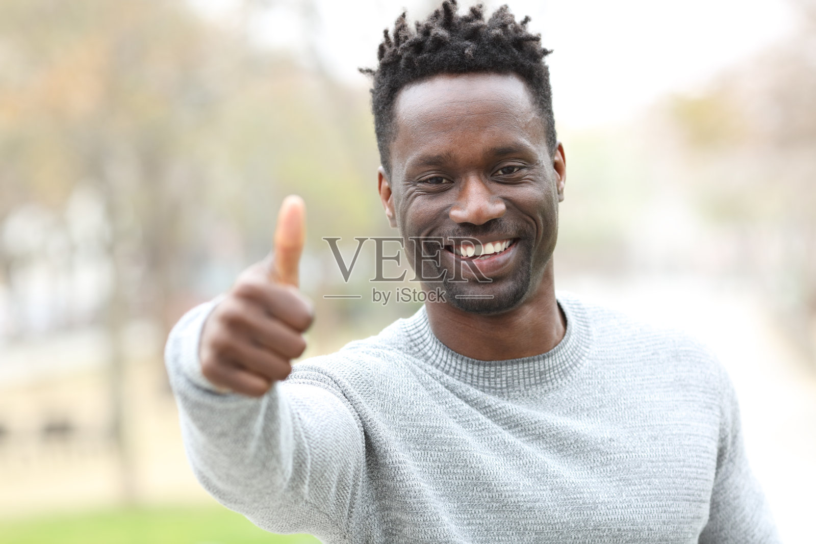 快乐的黑人在户外竖起大拇指照片摄影图片