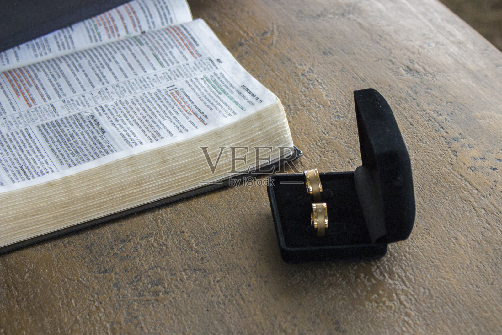结婚戒指在黑色天鹅绒盒子与圣经。结婚的概念。照片摄影图片