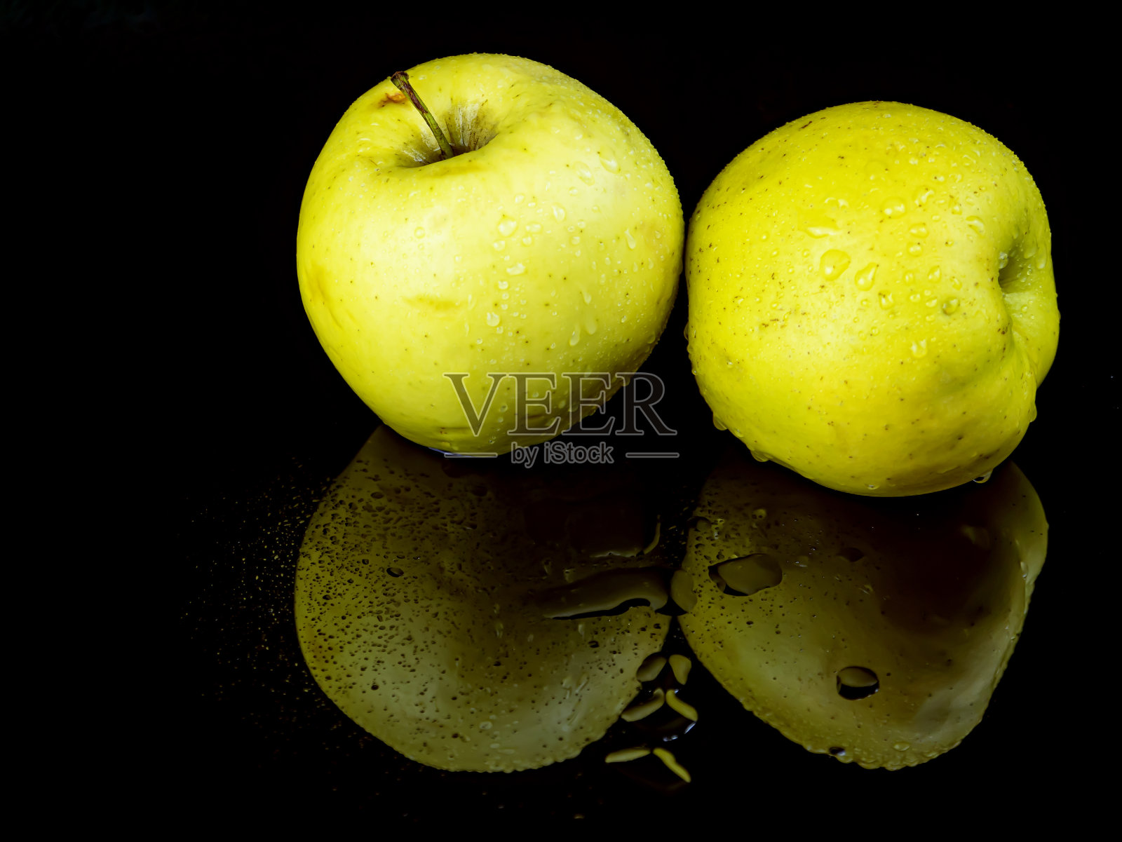 果青苹果在水滴在黑色玻璃的背景反射。照片摄影图片