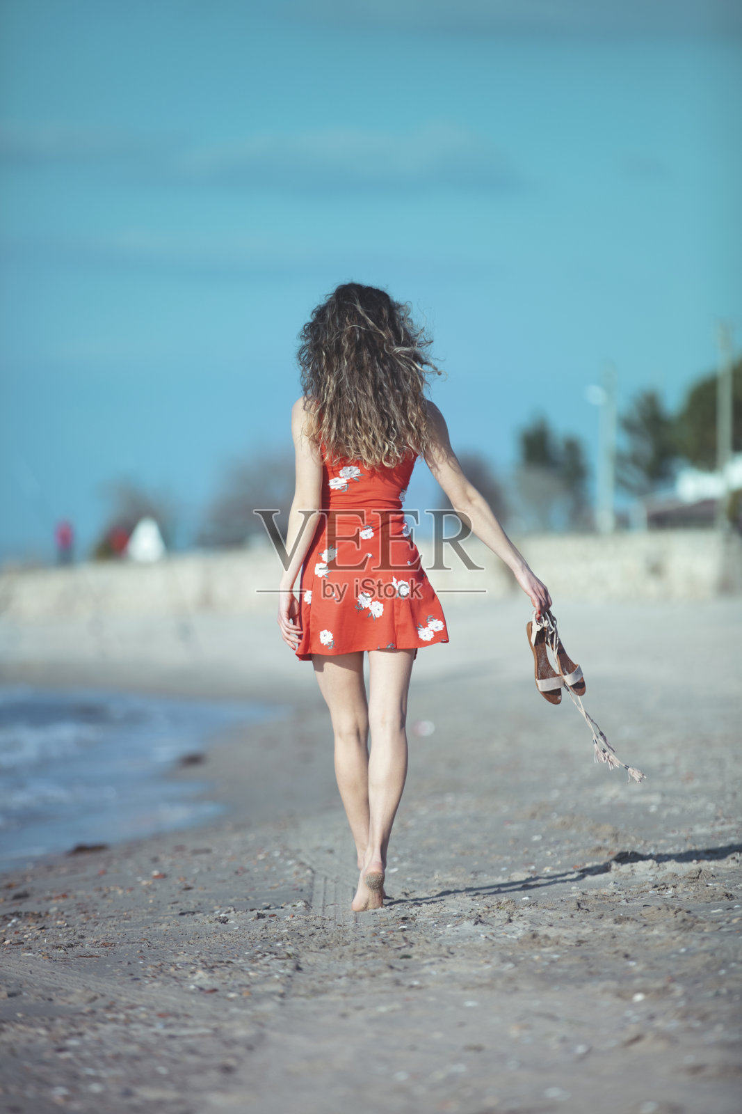 一个年轻女子独自走在海滩上照片摄影图片