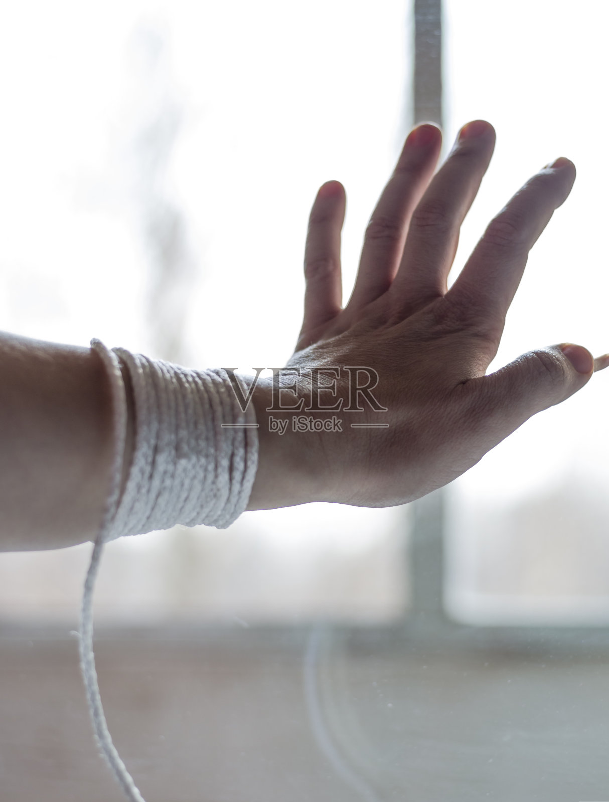 一个女人的手用一根绳子阻止一个人出去照片摄影图片