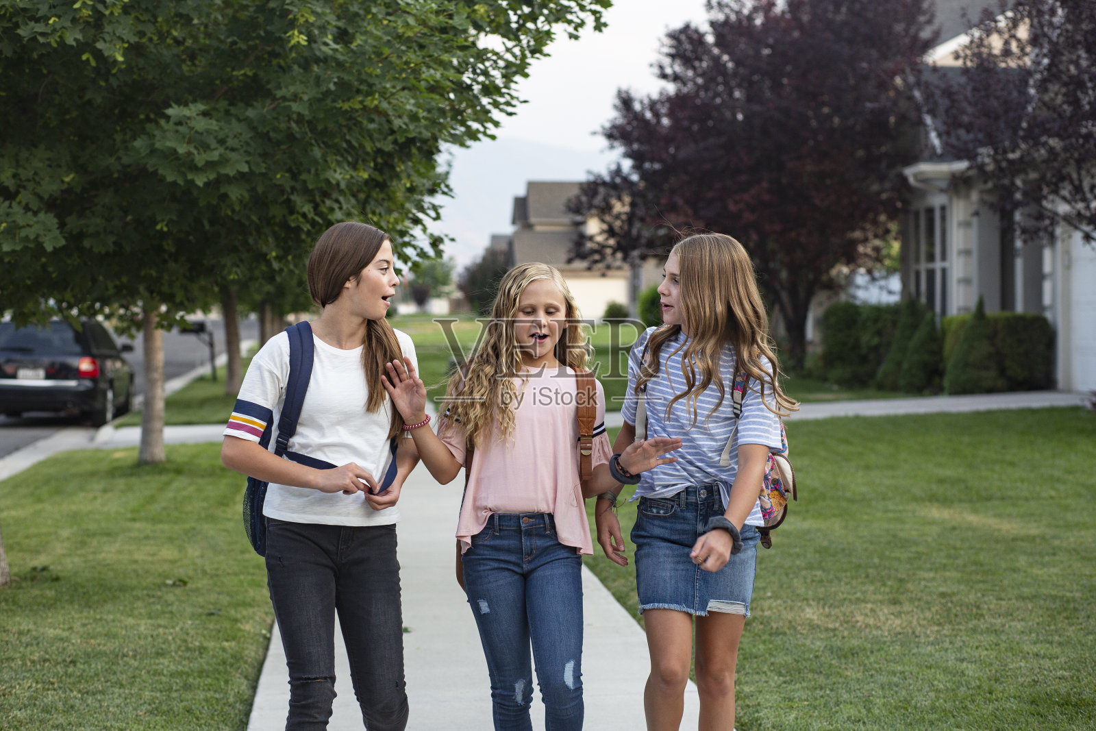 一群年轻的女性朋友和学生在放学回家的路上一起聊天照片摄影图片