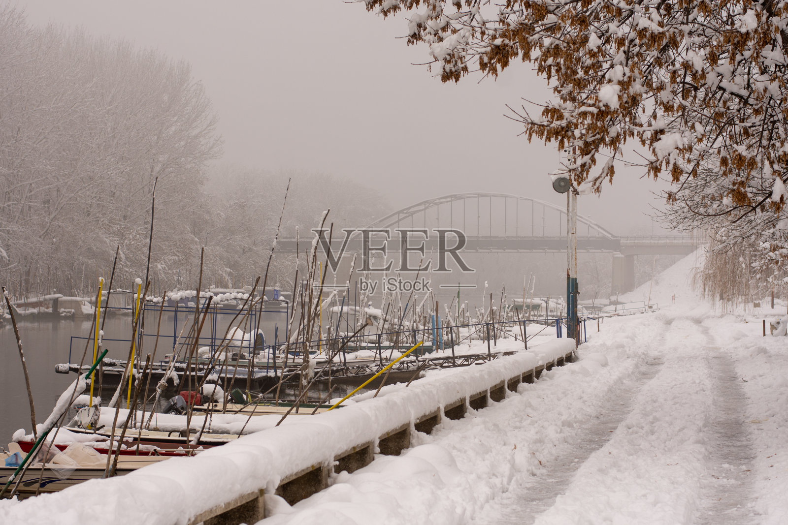 冬天的背景上有雪，河边有船。雾蒙蒙的冬日里，河上结了霜，下了雪。照片摄影图片
