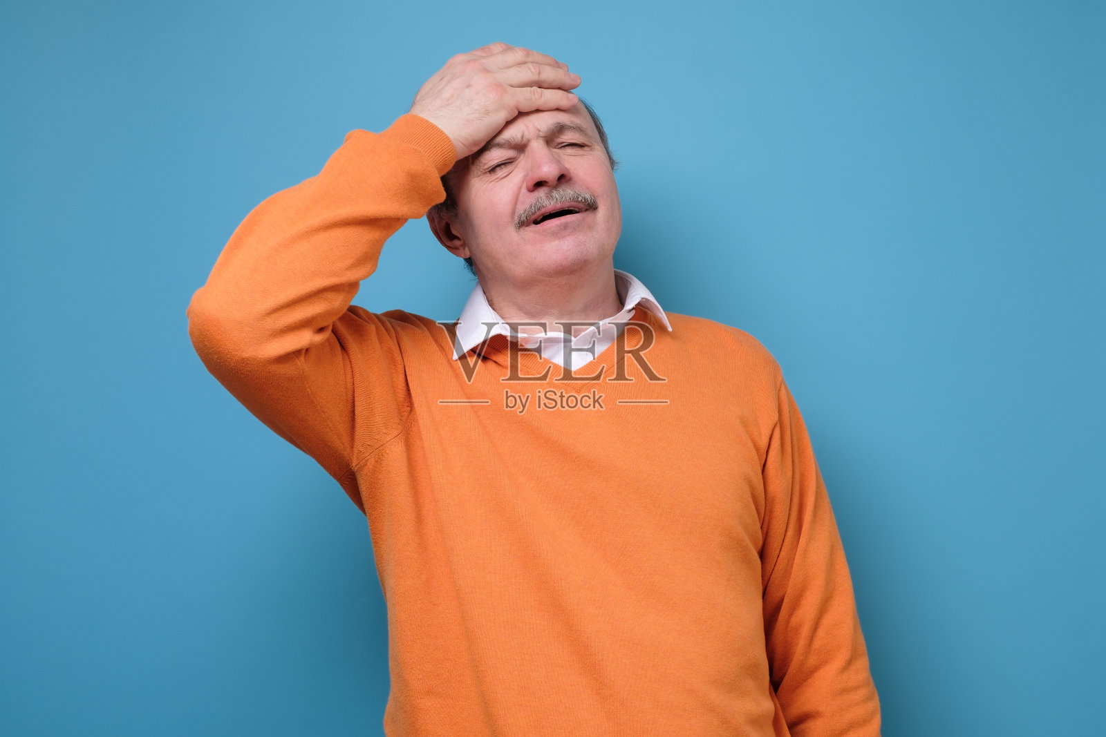 西班牙裔老年男子，流感或冠状病毒症状为头痛和发烧照片摄影图片