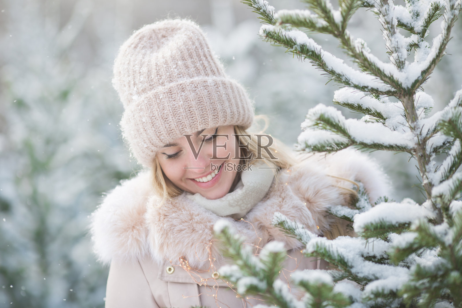 可爱的女孩的肖像看起来在一个冬天的一天云杉照片摄影图片