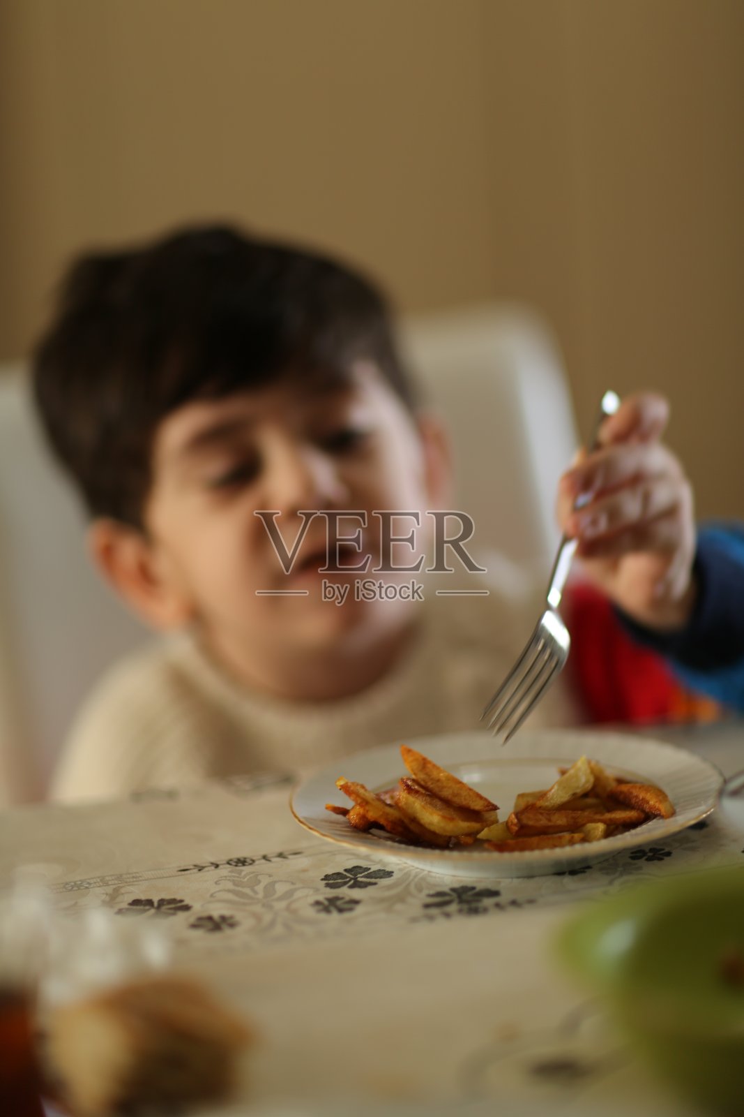 小男孩在吃炸土豆照片摄影图片