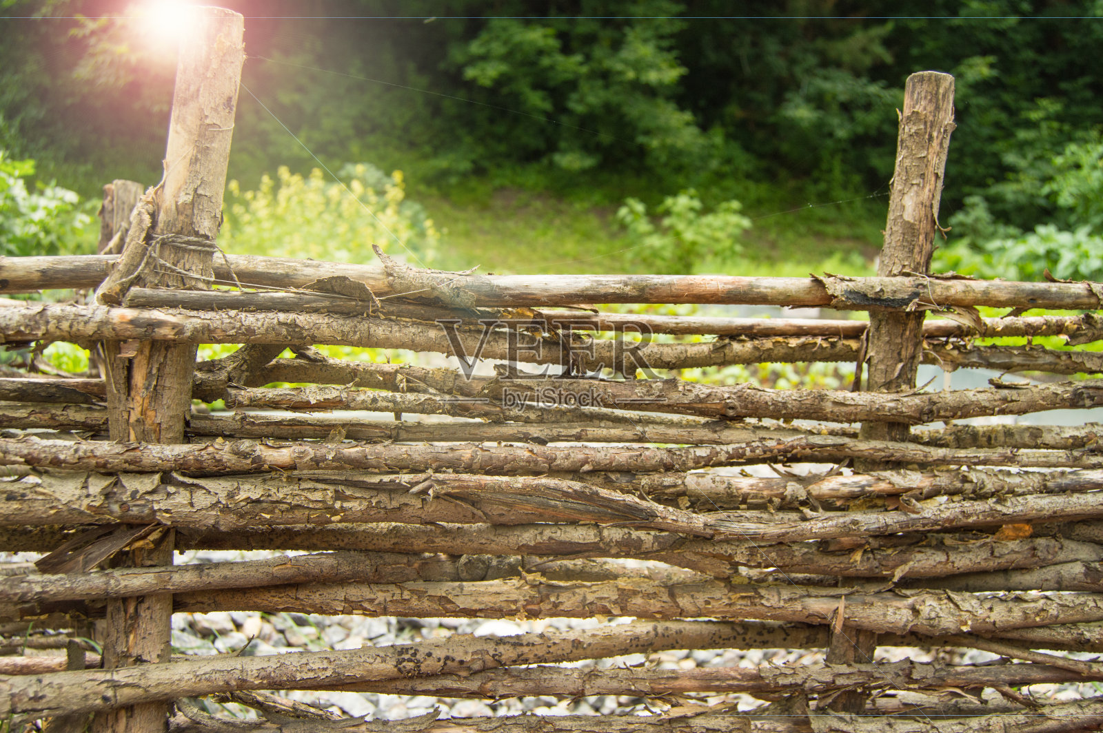 用长杆做成的古老的柳条篱笆，水平的复古背景，阳光透过篱笆的洞照射进来照片摄影图片