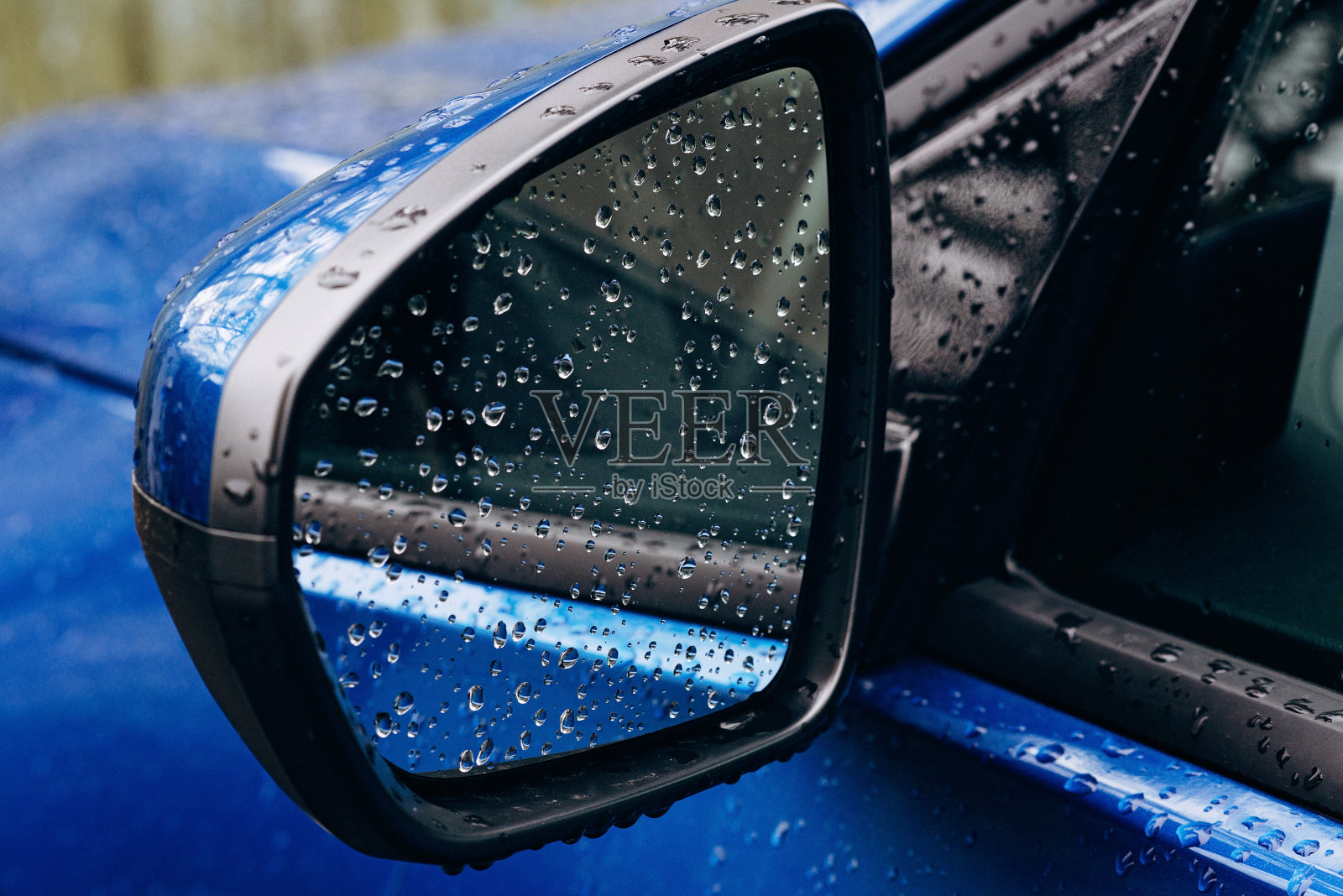 雨滴落在蓝色汽车的镜子上。秋天。软选择聚焦。照片摄影图片