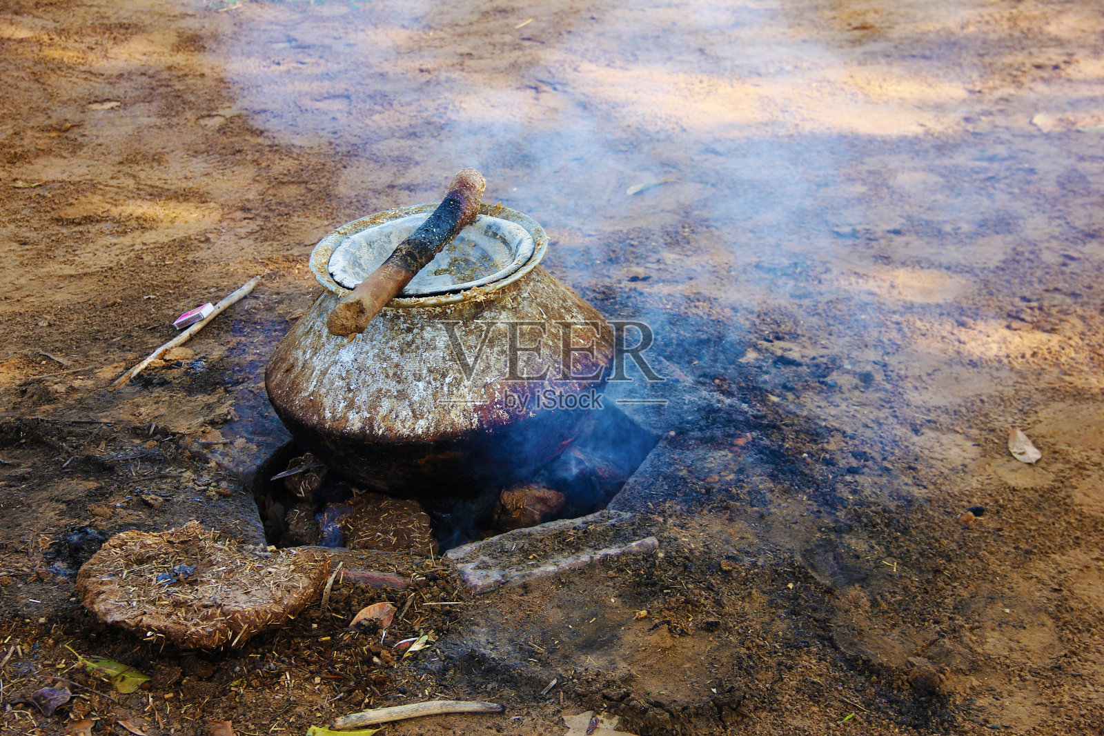 在农村，用一个小陶器来加热水牛的食物照片摄影图片