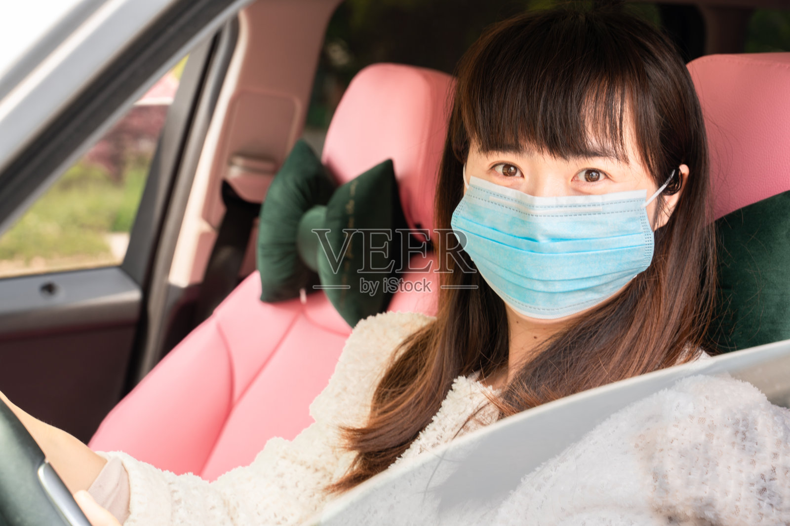 一个在车里戴着面具的亚洲女人照片摄影图片
