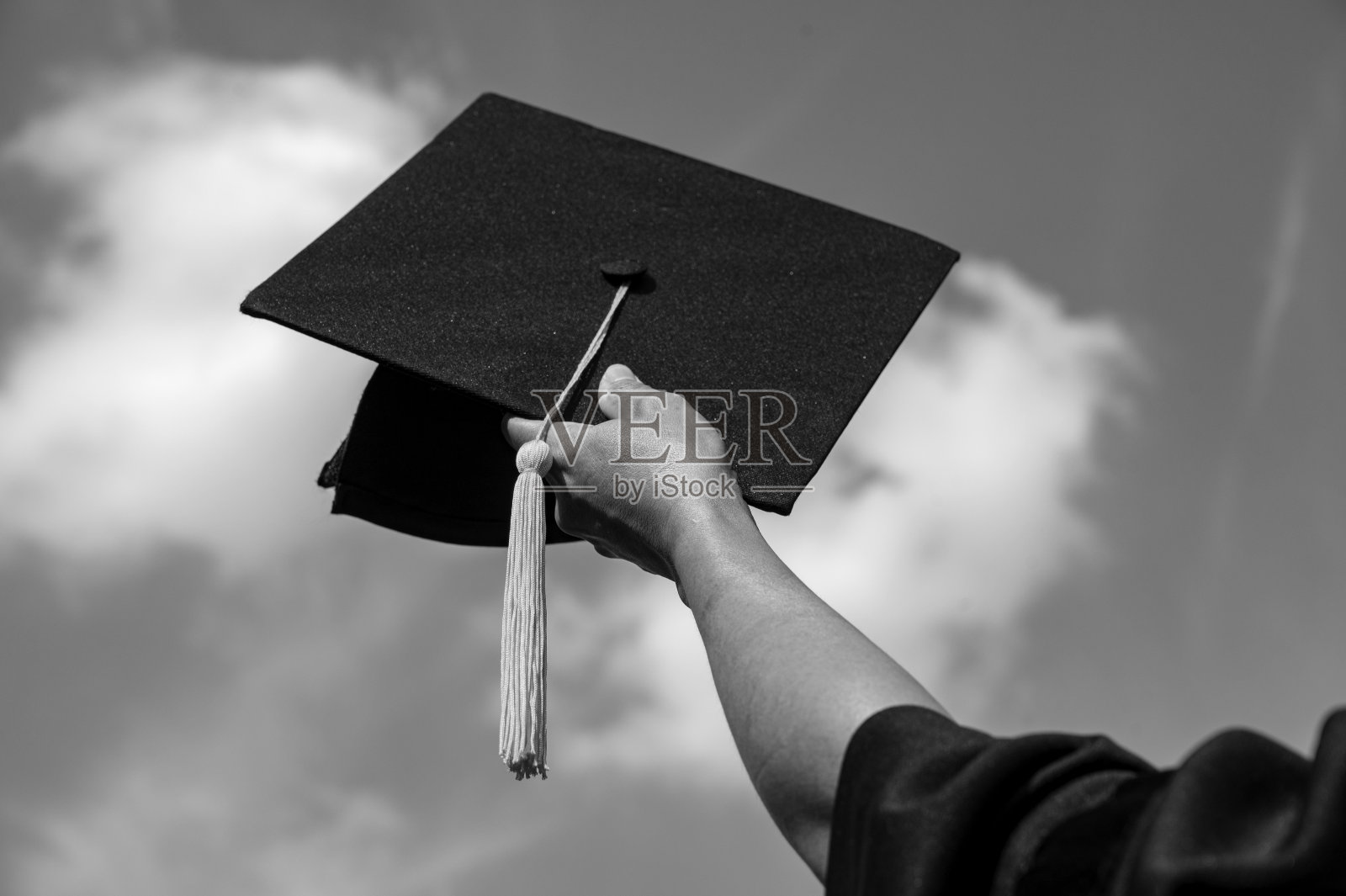 毕业典礼上，同学们手握毕业帽在灿烂的天空中成功毕业，在成功教育理念的高中，祝贺学位照片摄影图片