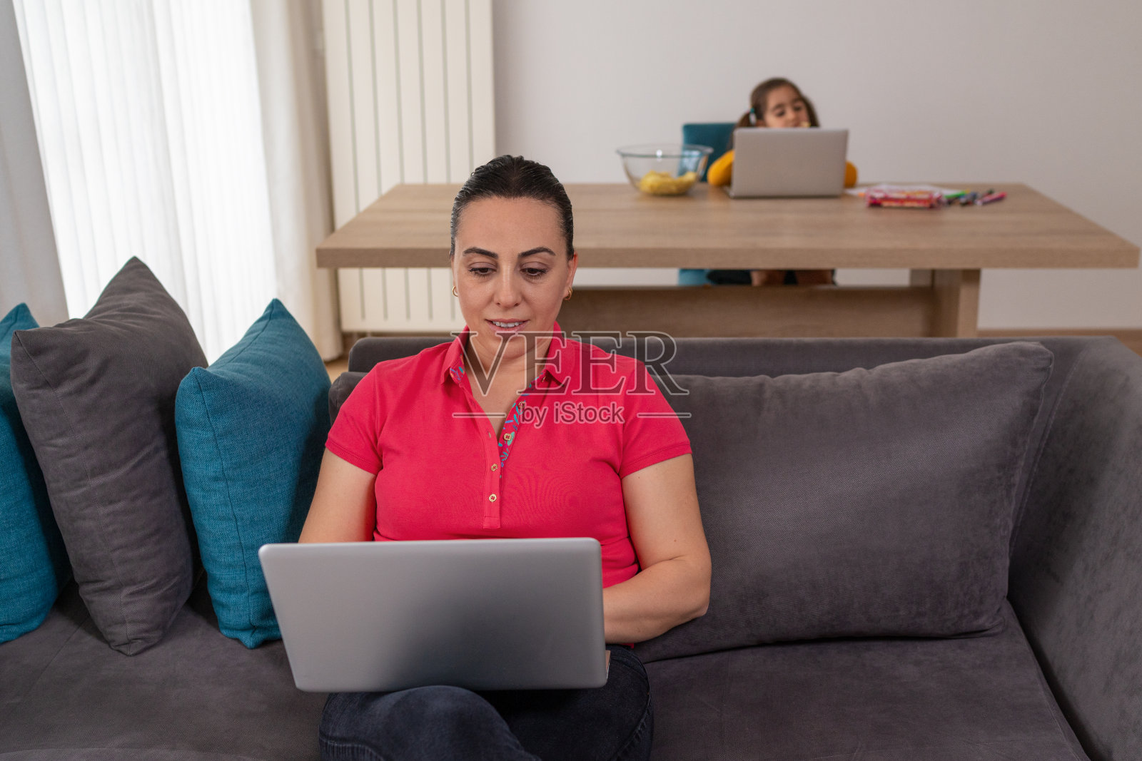母亲和女儿在家里用笔记本电脑工作照片摄影图片
