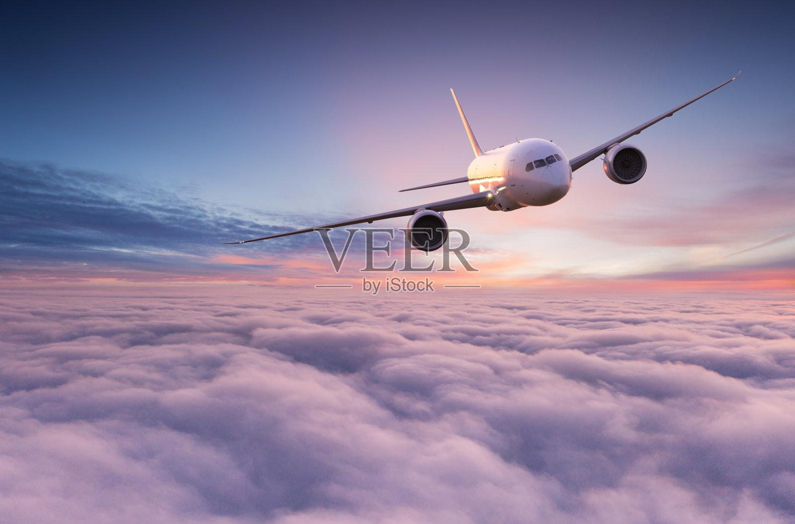 商业飞机在戏剧性的云层上空飞行。照片摄影图片