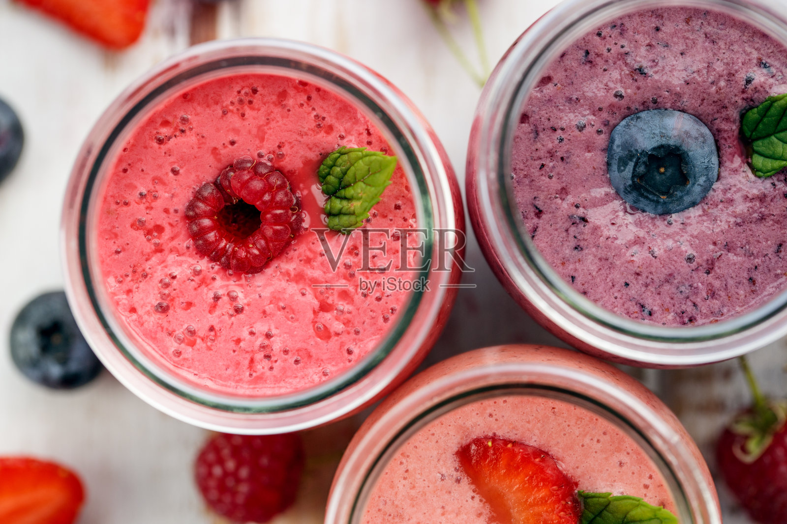 浆果冰沙，覆盆子，蓝莓和草莓在玻璃罐中俯视图，照片摄影图片