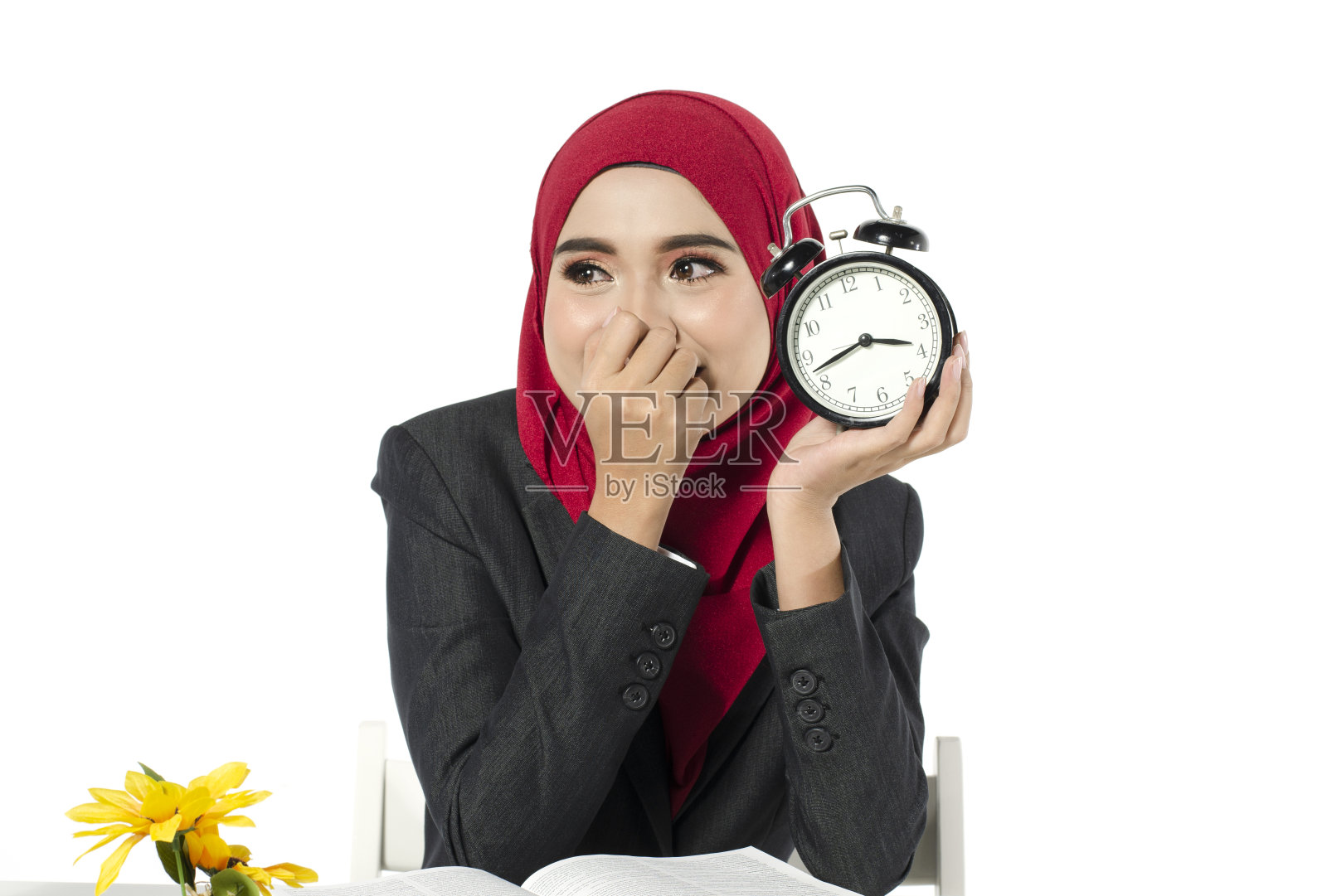 微笑的亚洲商务妇女与头巾持有闹钟的白色背景照片摄影图片
