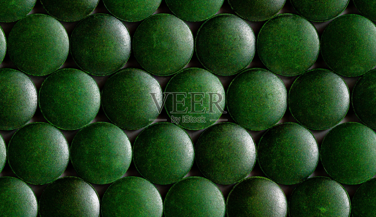 许多绿色有机螺旋藻片的无缝六角形图案紧密地平铺在一层上照片摄影图片