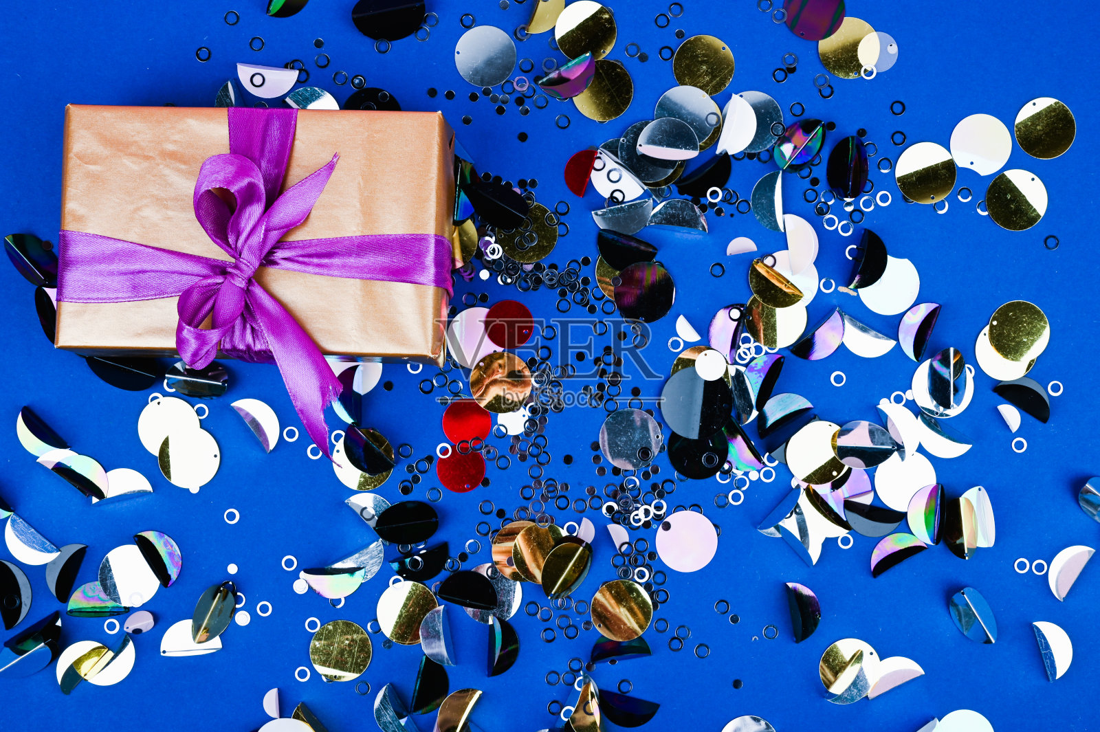 礼品黑色盒子与蝴蝶结在多色的背景。生日或婚礼用的平铺排版。1年的概念照片摄影图片
