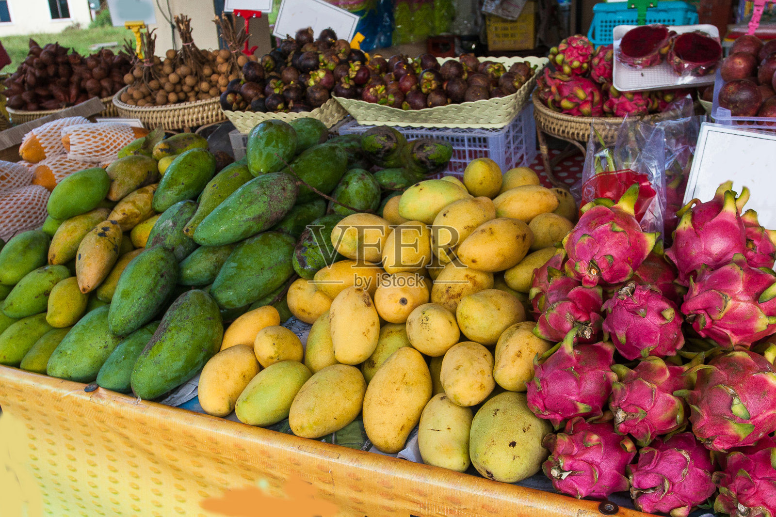 新鲜成熟的芒果和龙在泰国的集市上出售。亚洲。水果。旅行。照片摄影图片