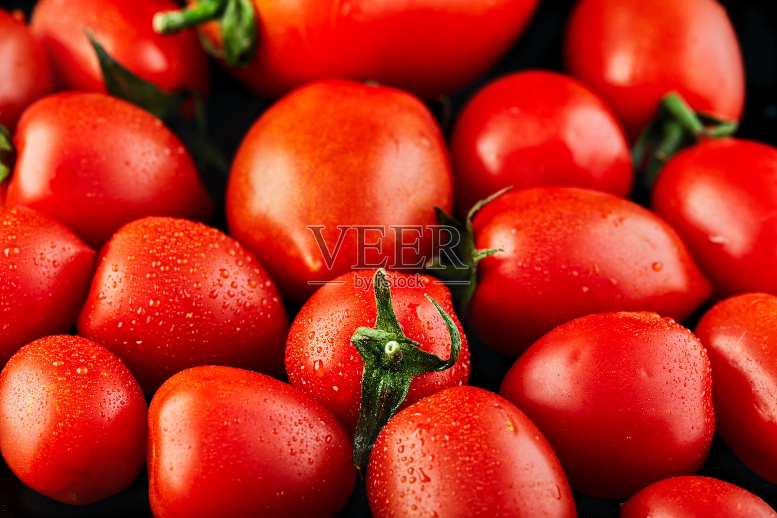 大番茄和小葡萄樱桃番茄在黑色的背景。低热量食物照片摄影图片